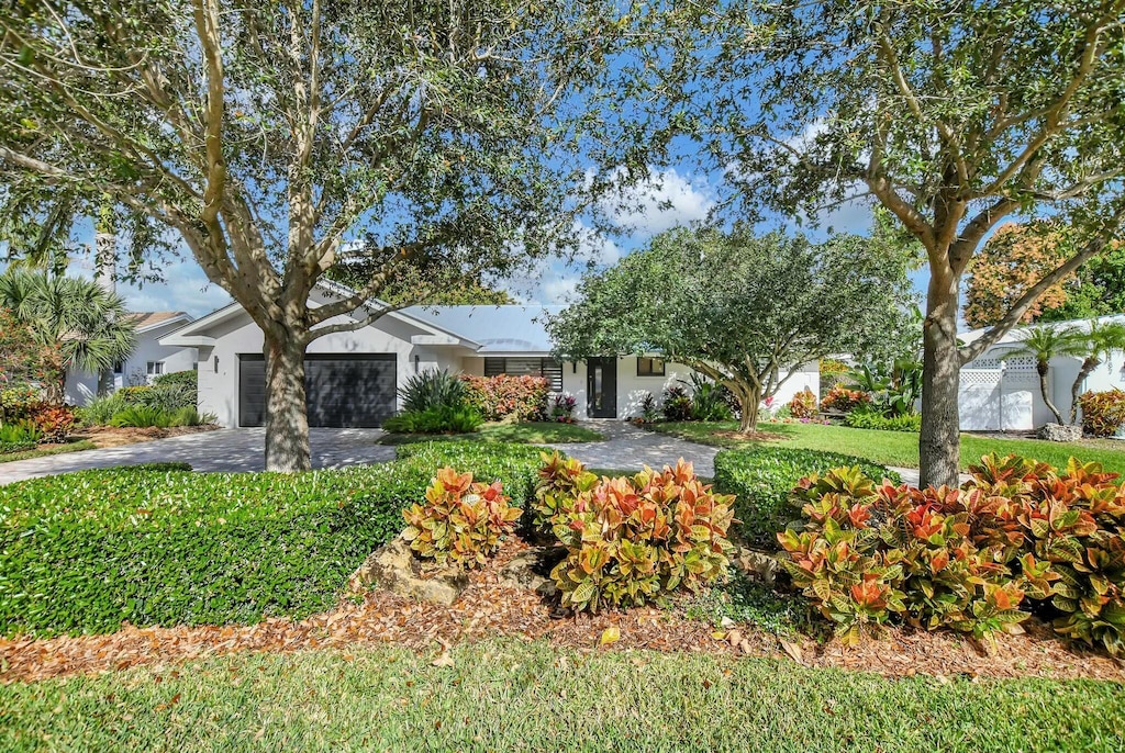 ranch-style home with a front lawn and a garage