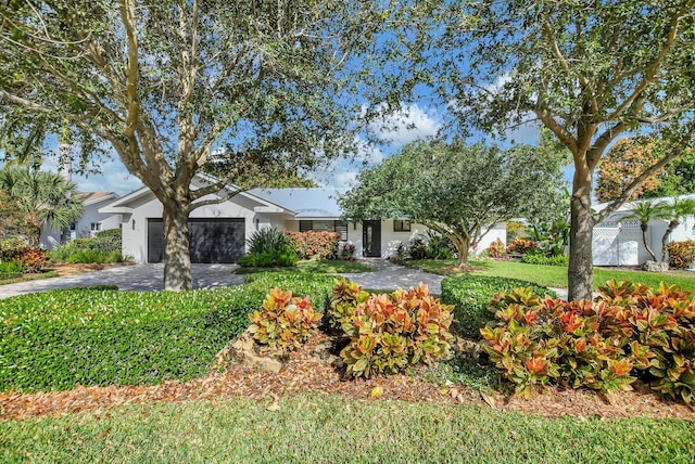 ranch-style home with a front lawn and a garage