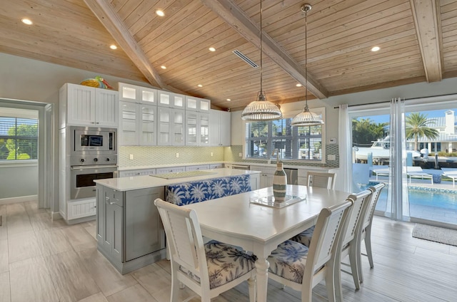 dining room featuring wooden ceiling, breakfast area, and lofted ceiling with beams