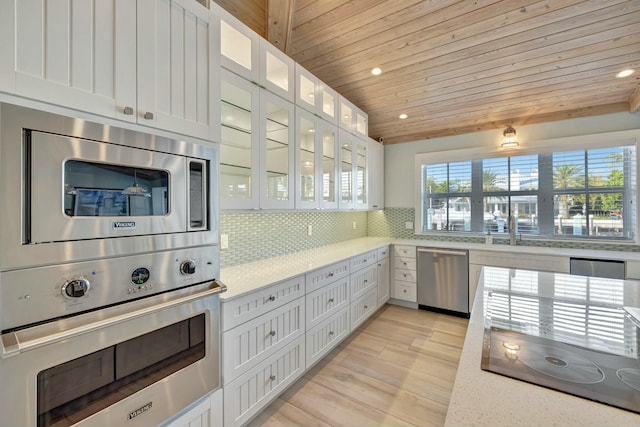 kitchen with tasteful backsplash, appliances with stainless steel finishes, wood ceiling, and white cabinetry