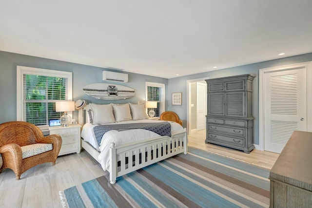 bedroom featuring a wall mounted AC, a closet, and wood-type flooring