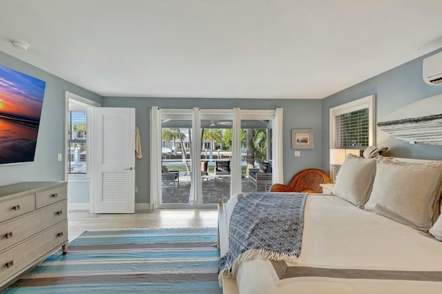 bedroom with light hardwood / wood-style flooring, access to outside, and multiple windows