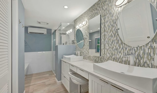 bathroom with vanity, a wall unit AC, and plus walk in shower