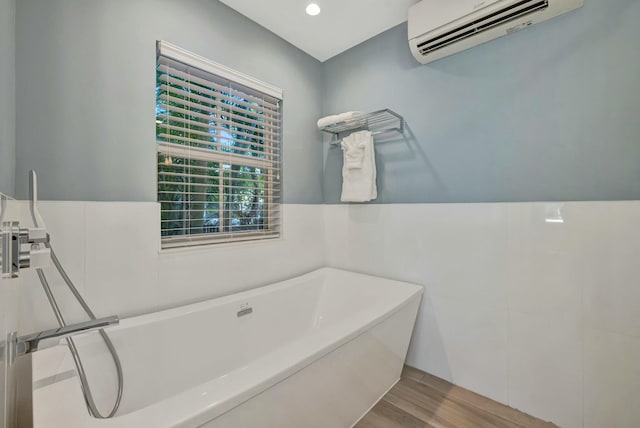 bathroom featuring a wall mounted AC, a bath, and wood-type flooring