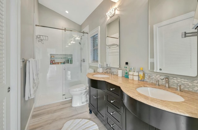 bathroom with toilet, a shower with door, backsplash, lofted ceiling, and vanity