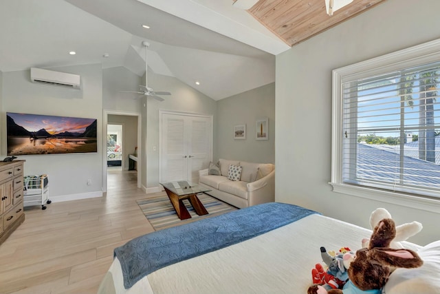 bedroom featuring lofted ceiling, light hardwood / wood-style floors, a closet, a wall mounted AC, and ceiling fan