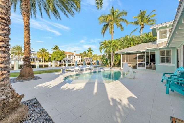 view of pool featuring a sunroom and a patio