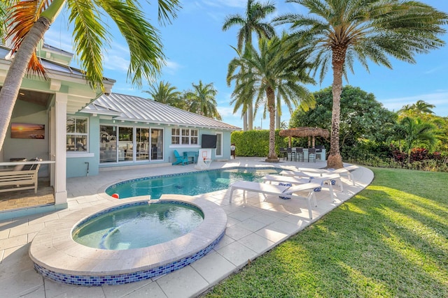 view of swimming pool featuring an in ground hot tub, a lawn, and a patio