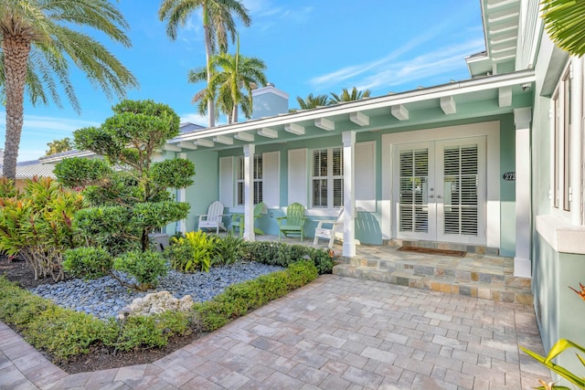 entrance to property with a porch and french doors