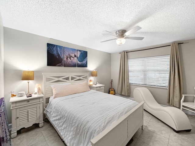 bedroom featuring light tile patterned floors, a textured ceiling, and ceiling fan