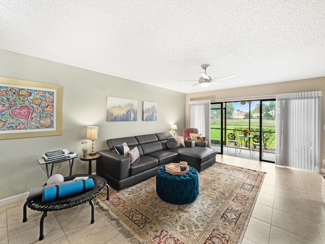 living room featuring ceiling fan, light tile patterned floors, and a textured ceiling