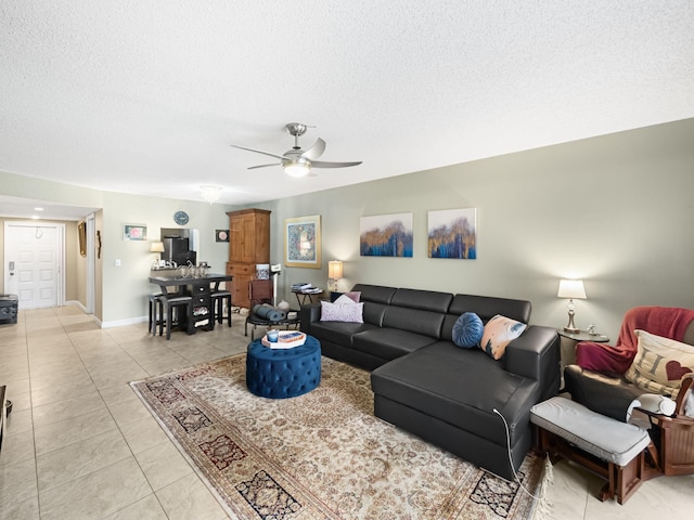 tiled living room with a textured ceiling and ceiling fan