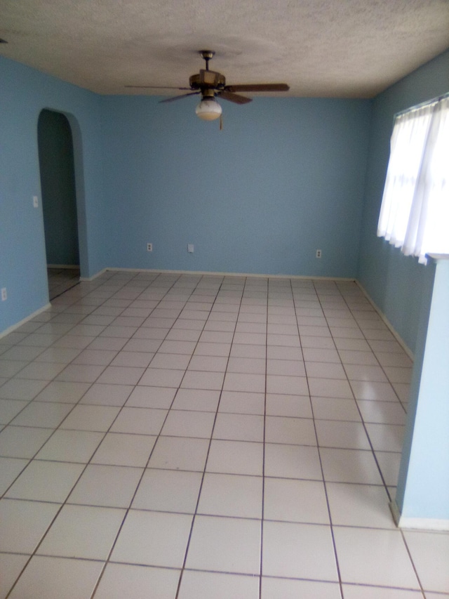 tiled spare room with ceiling fan and a textured ceiling