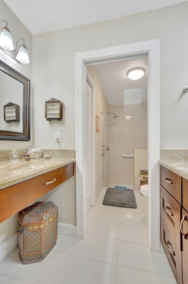 bathroom featuring vanity, tile patterned flooring, and tiled shower