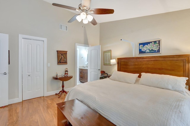 bedroom with ceiling fan, connected bathroom, light wood-type flooring, a closet, and lofted ceiling