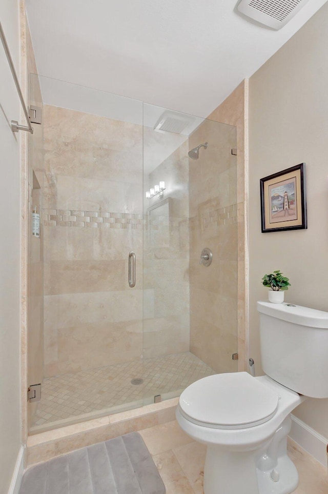 bathroom with tile patterned floors, toilet, and a shower with door