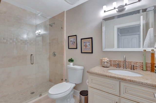 bathroom with an enclosed shower, vanity, and toilet