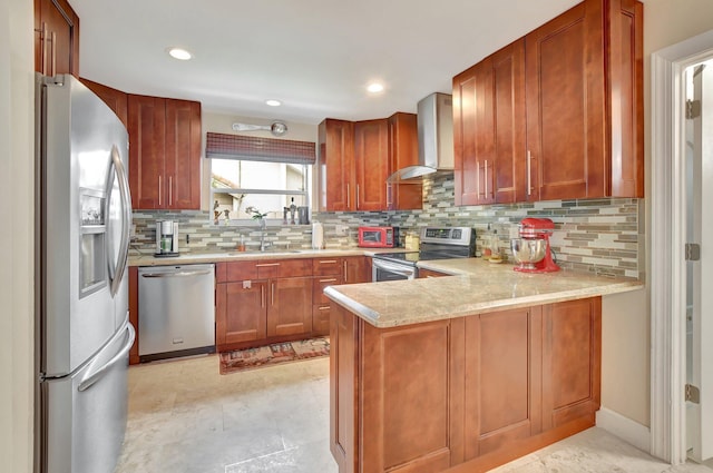 kitchen featuring wall chimney exhaust hood, stainless steel appliances, tasteful backsplash, sink, and kitchen peninsula