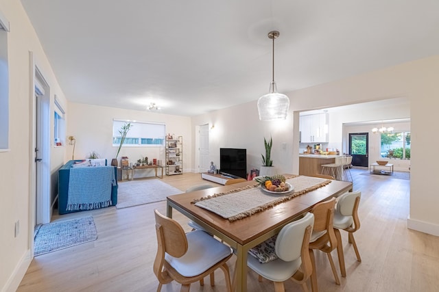 dining space with a chandelier and light wood-type flooring