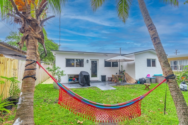 back of property with a yard and a patio