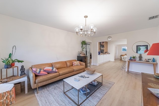 living room with an inviting chandelier and light hardwood / wood-style floors