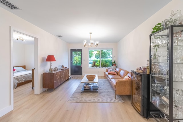 living room with an inviting chandelier and light hardwood / wood-style flooring