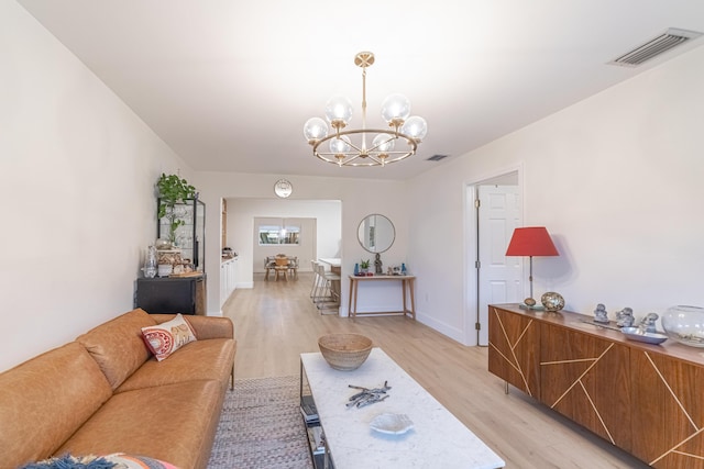 living room with a notable chandelier and light wood-type flooring