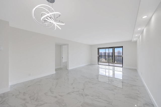 unfurnished room featuring a chandelier