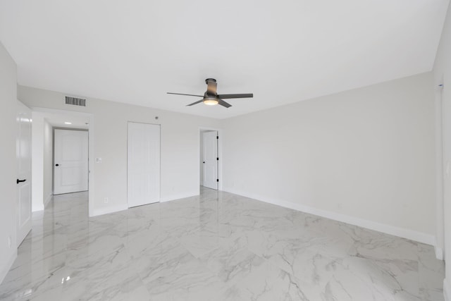 interior space with baseboards, marble finish floor, visible vents, and a ceiling fan