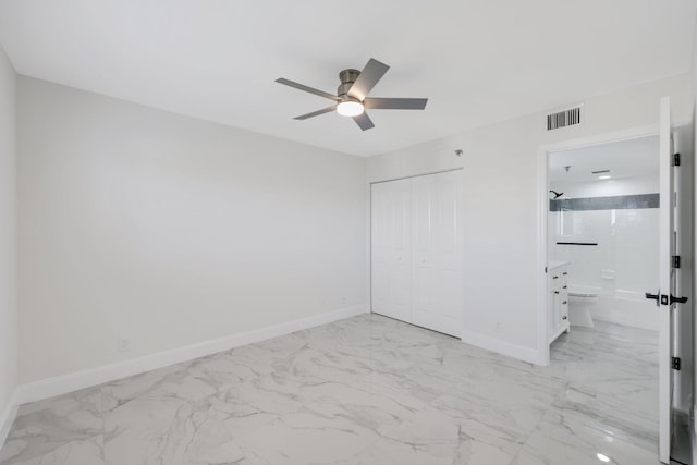 unfurnished bedroom with ceiling fan, a closet, and ensuite bath