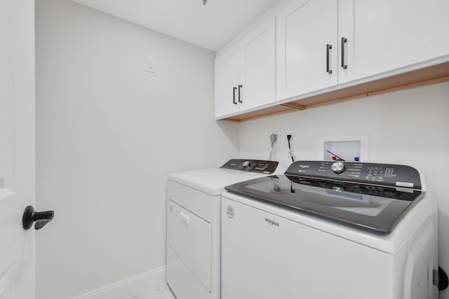 washroom with cabinet space, baseboards, and washer and clothes dryer