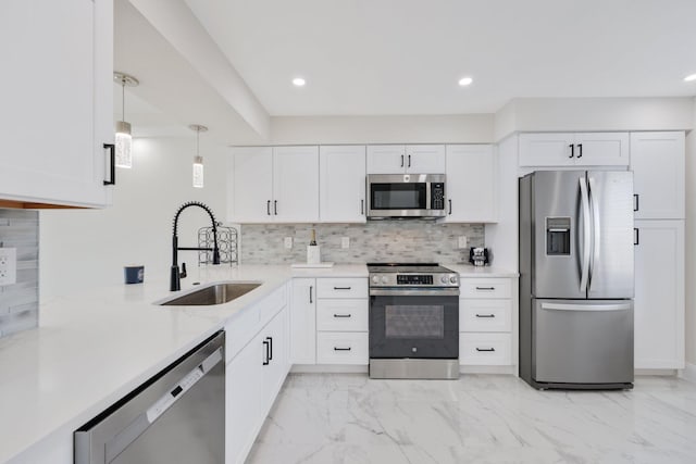 kitchen featuring decorative light fixtures, white cabinetry, stainless steel appliances, decorative backsplash, and sink