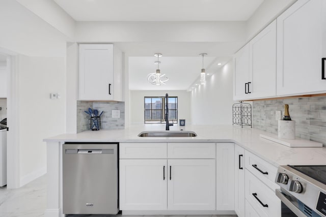 kitchen with appliances with stainless steel finishes, pendant lighting, white cabinetry, and sink