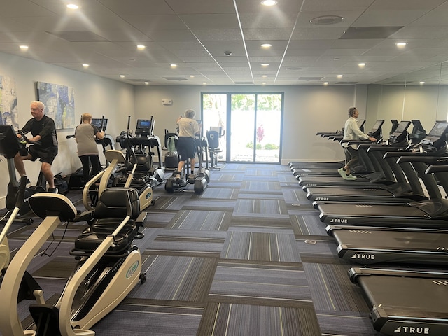 exercise room with carpet flooring and a paneled ceiling