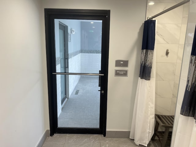 bathroom with tile patterned floors, elevator, and a shower with shower curtain