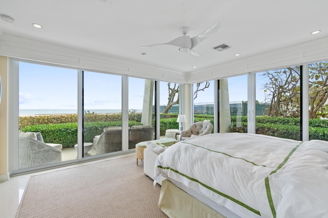 bedroom featuring ceiling fan, multiple windows, and a water view