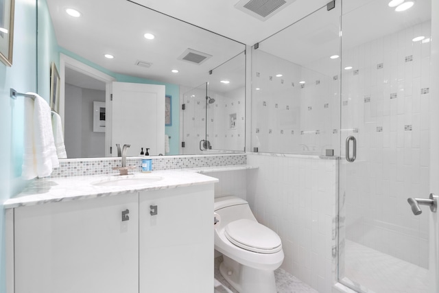 bathroom with toilet, walk in shower, backsplash, and vanity