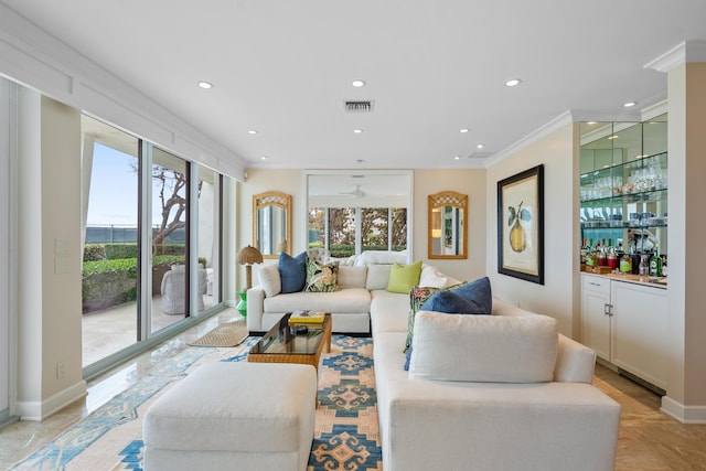 living room featuring ceiling fan, ornamental molding, and bar