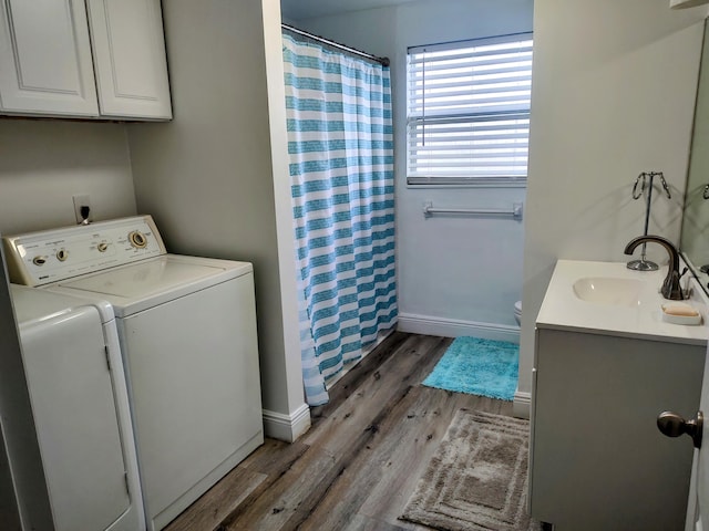 laundry area featuring dark wood-type flooring, sink, and independent washer and dryer