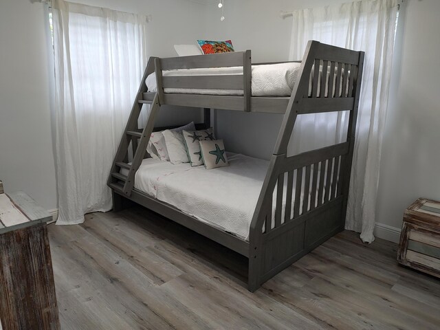 bedroom featuring ceiling fan, wood-type flooring, and ornamental molding