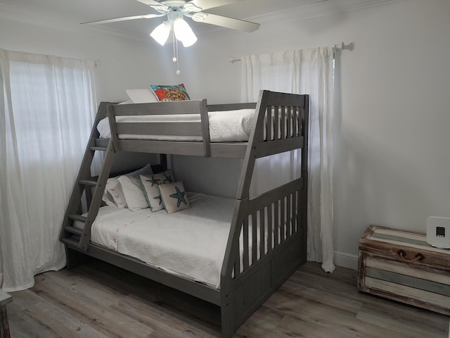 bedroom featuring ceiling fan, ornamental molding, and hardwood / wood-style flooring