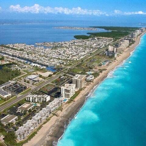 drone / aerial view featuring a water view and a view of the beach