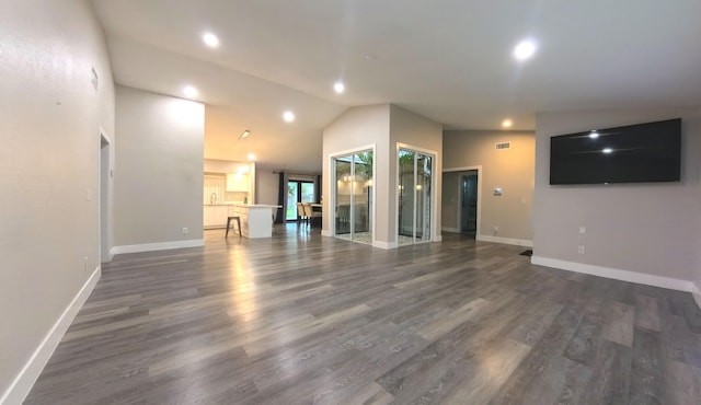 unfurnished living room featuring lofted ceiling and dark hardwood / wood-style flooring