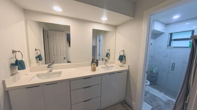 bathroom with vanity, toilet, and a shower with door