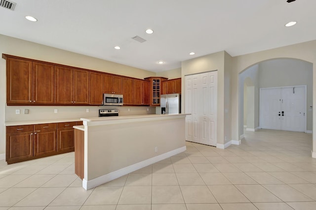 kitchen featuring light tile patterned floors, appliances with stainless steel finishes, and a center island