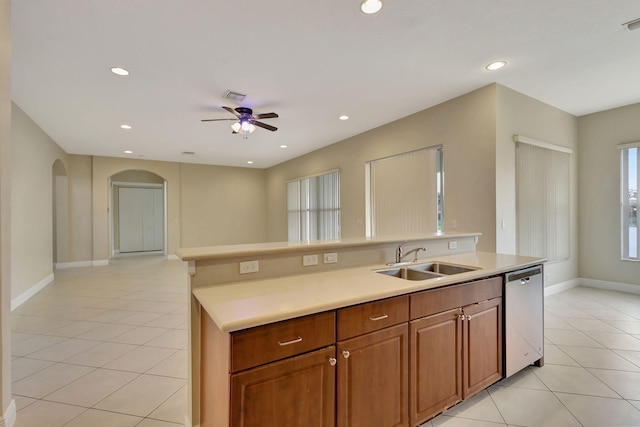 kitchen with ceiling fan, a center island with sink, stainless steel dishwasher, sink, and light tile patterned flooring