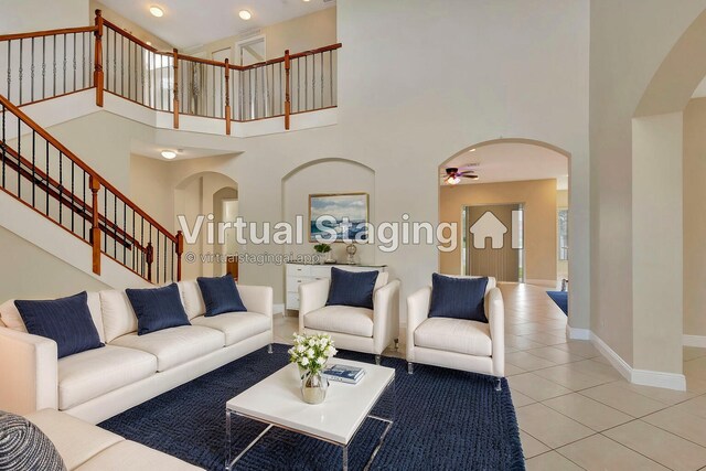 tiled foyer featuring ceiling fan and a towering ceiling