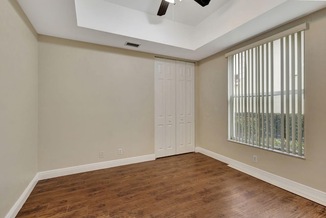 empty room with ceiling fan and dark wood-type flooring