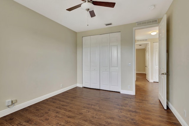 unfurnished bedroom with dark wood-type flooring, ceiling fan, and a closet