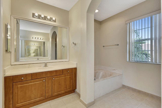 bathroom featuring vanity, tile patterned floors, and a bath